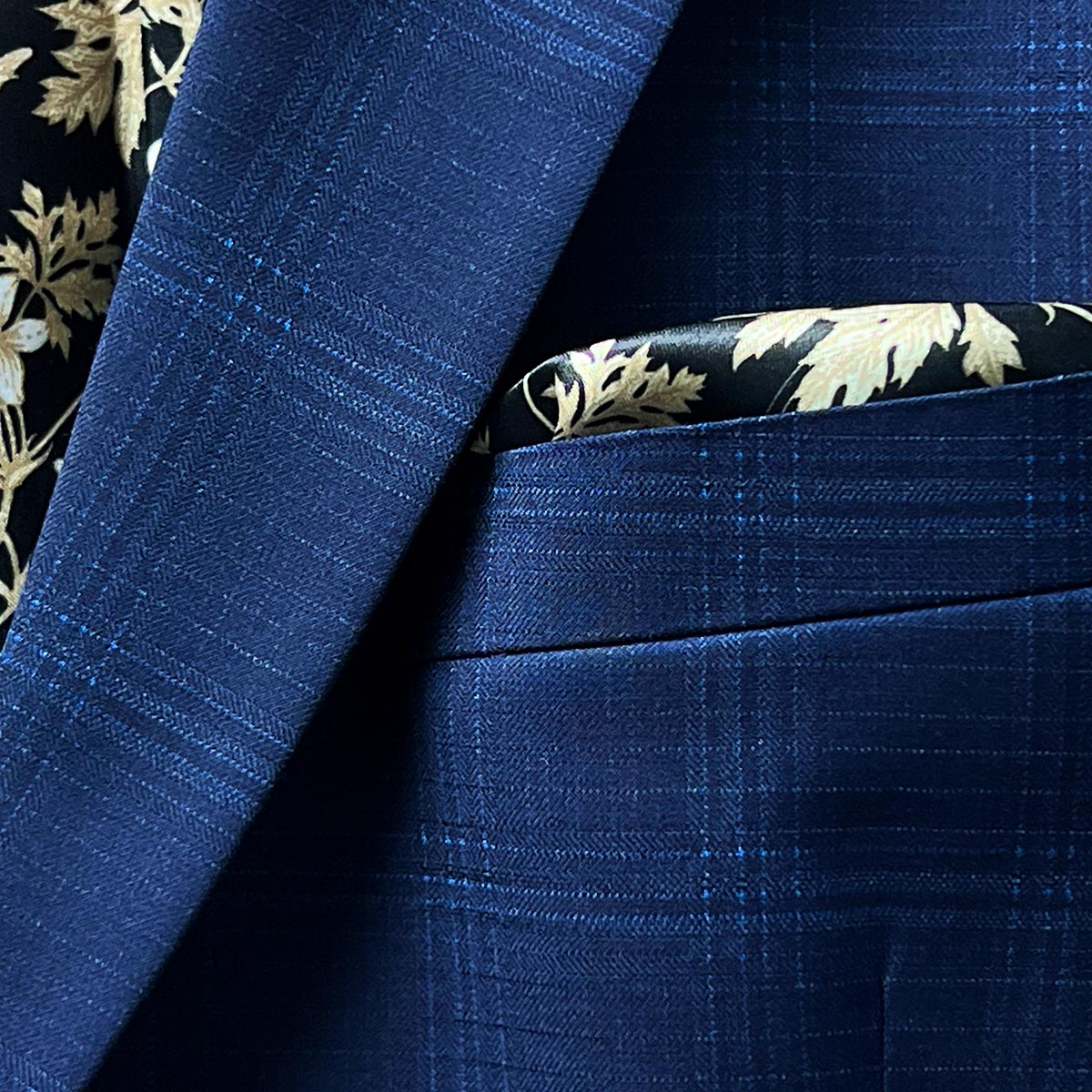 A stylish pocket square adding a touch of sophistication to a midnight blue windowpane suit.