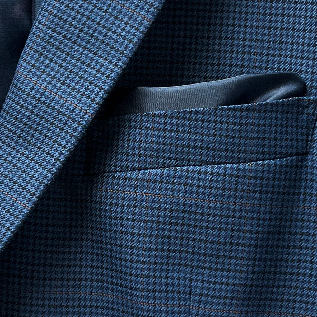 Built-in pocket square detail on the prussian blue suit jacket, adding a touch of elegance and practicality.