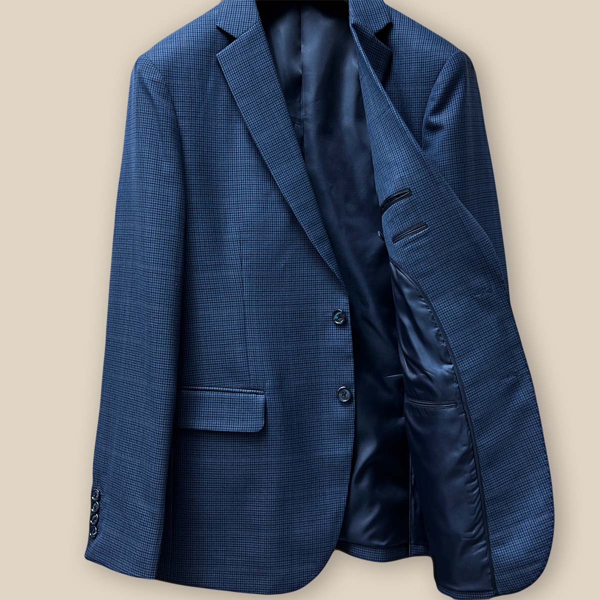 Interior view of the left side of the prussian blue suit jacket, highlighting the dark blue bemberg plain lining.