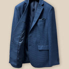 Interior view of the right side of the prussian blue suit jacket, showing the fine craftsmanship and dark blue bemberg lining.