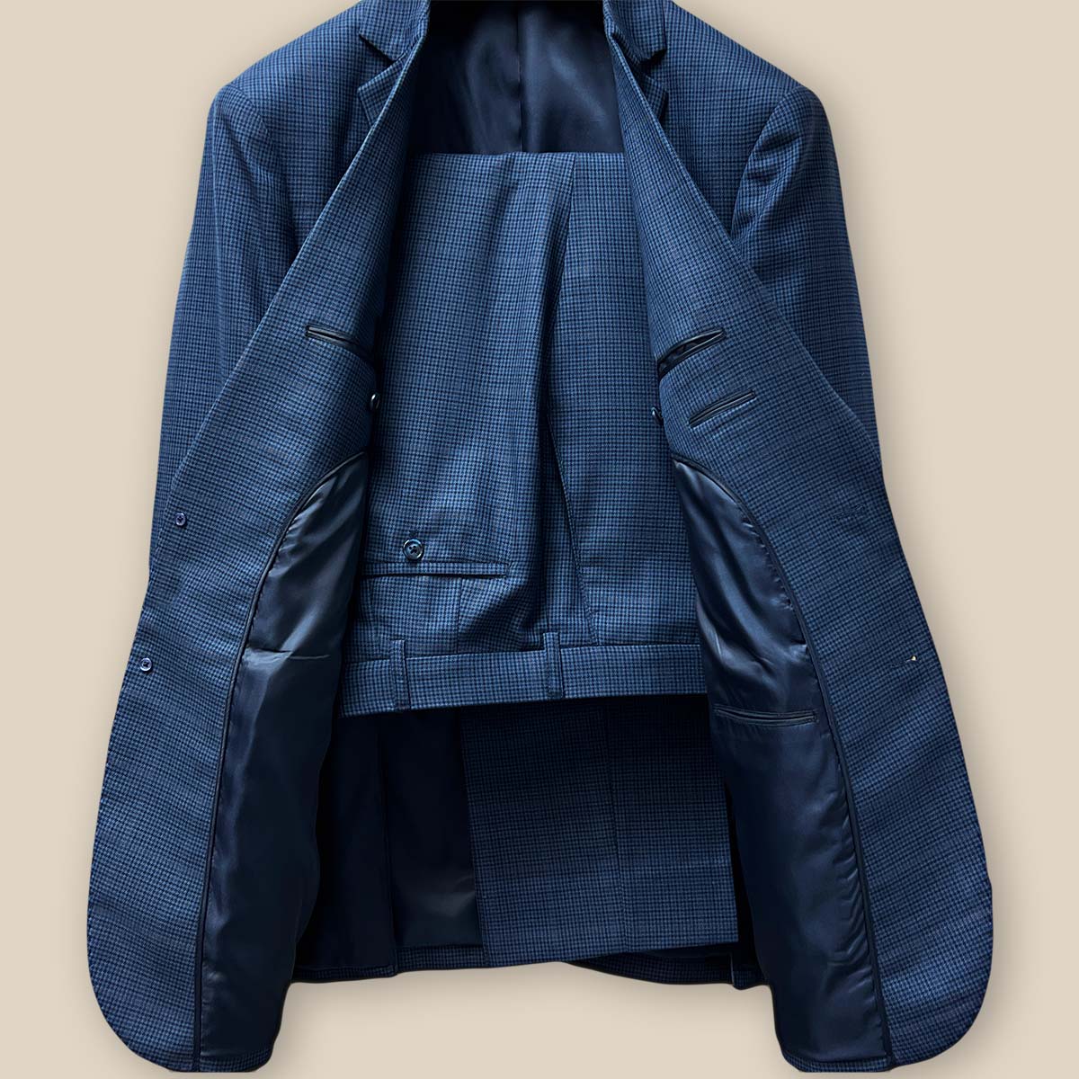 Full view of the prussian blue two-piece suit, displaying the elegant houndstooth with faint pastel orange windowpane design.