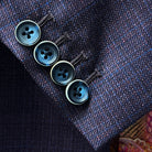 Close-up of working sleeve buttonholes with navy marble bone buttons