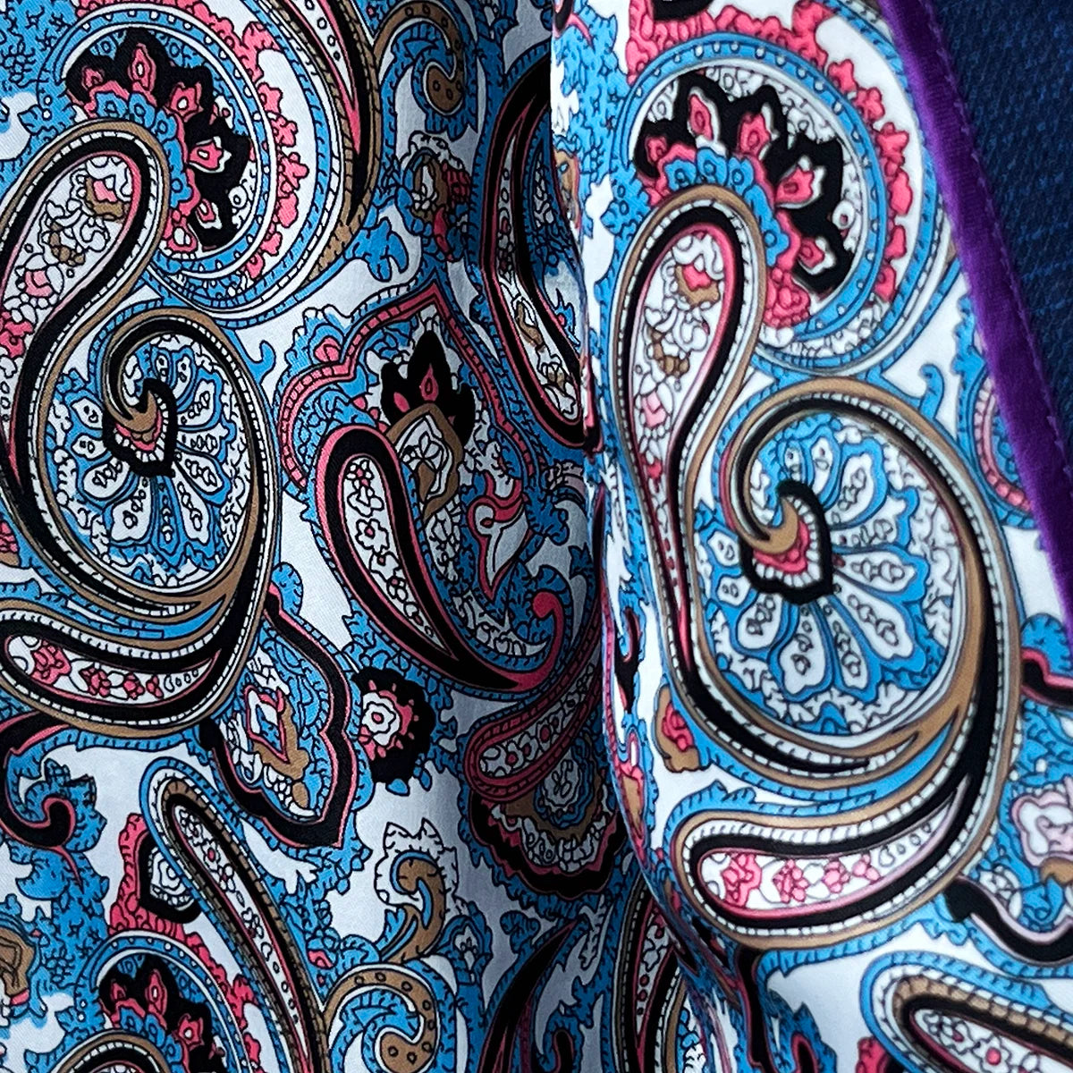 View of the flash linings with a multi-color paisley print inside the royal blue suit jacket.