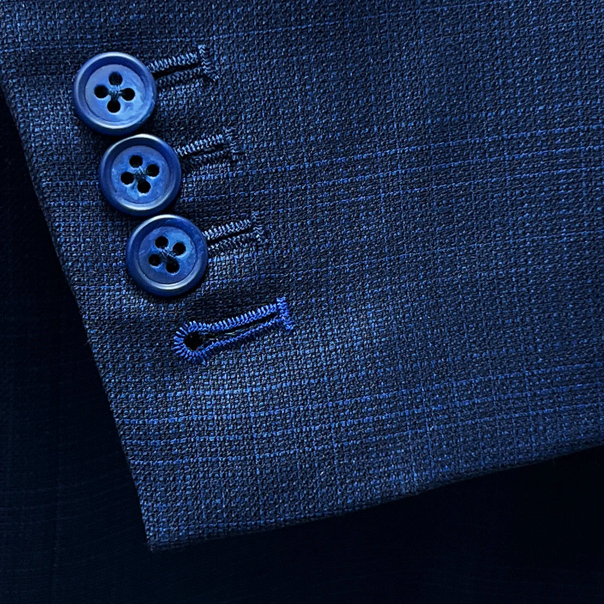 Close-up of the functional sleeve buttonholes with royal blue contrast stitching.