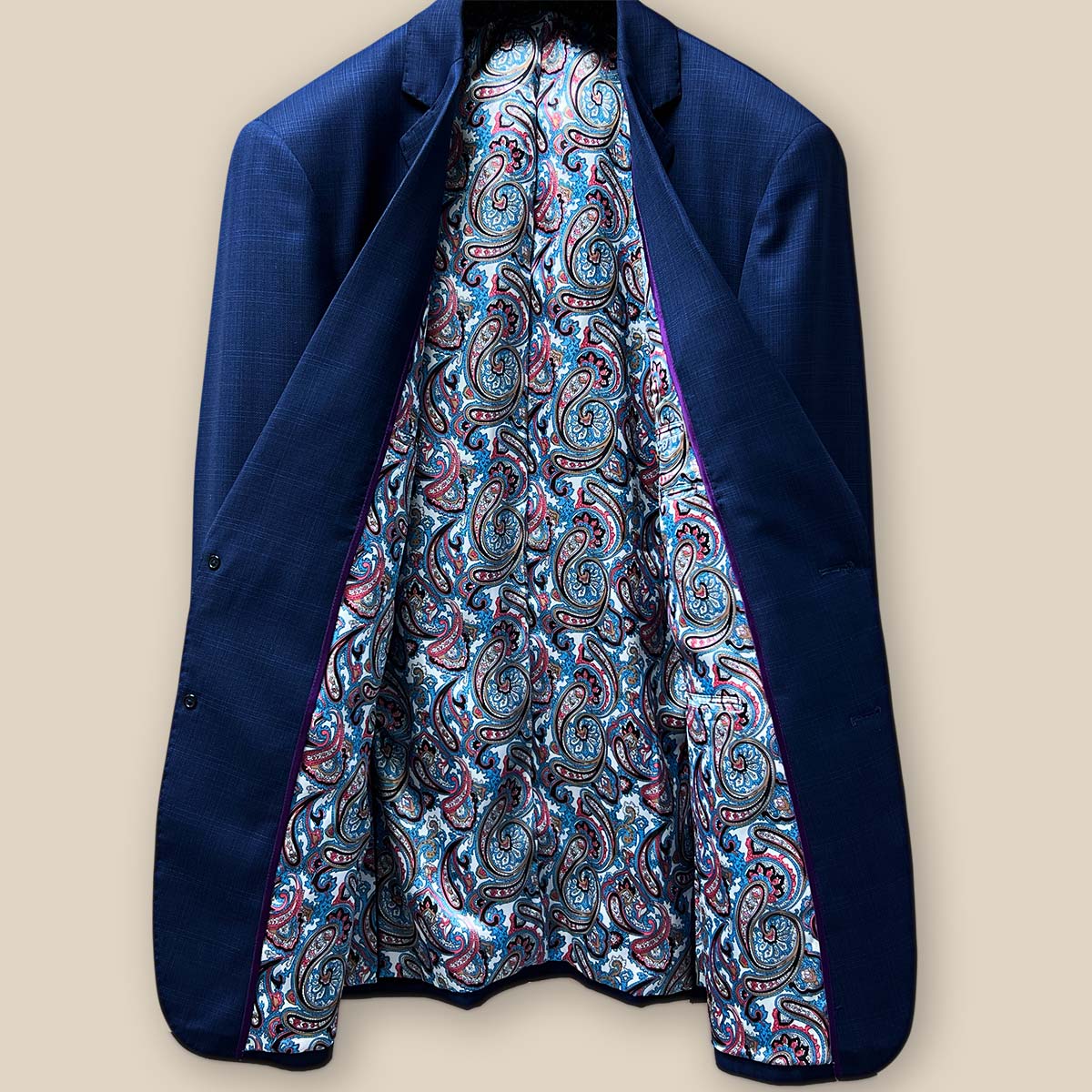 Full inside view of the royal blue suit jacket highlighting the vibrant paisley print lining.