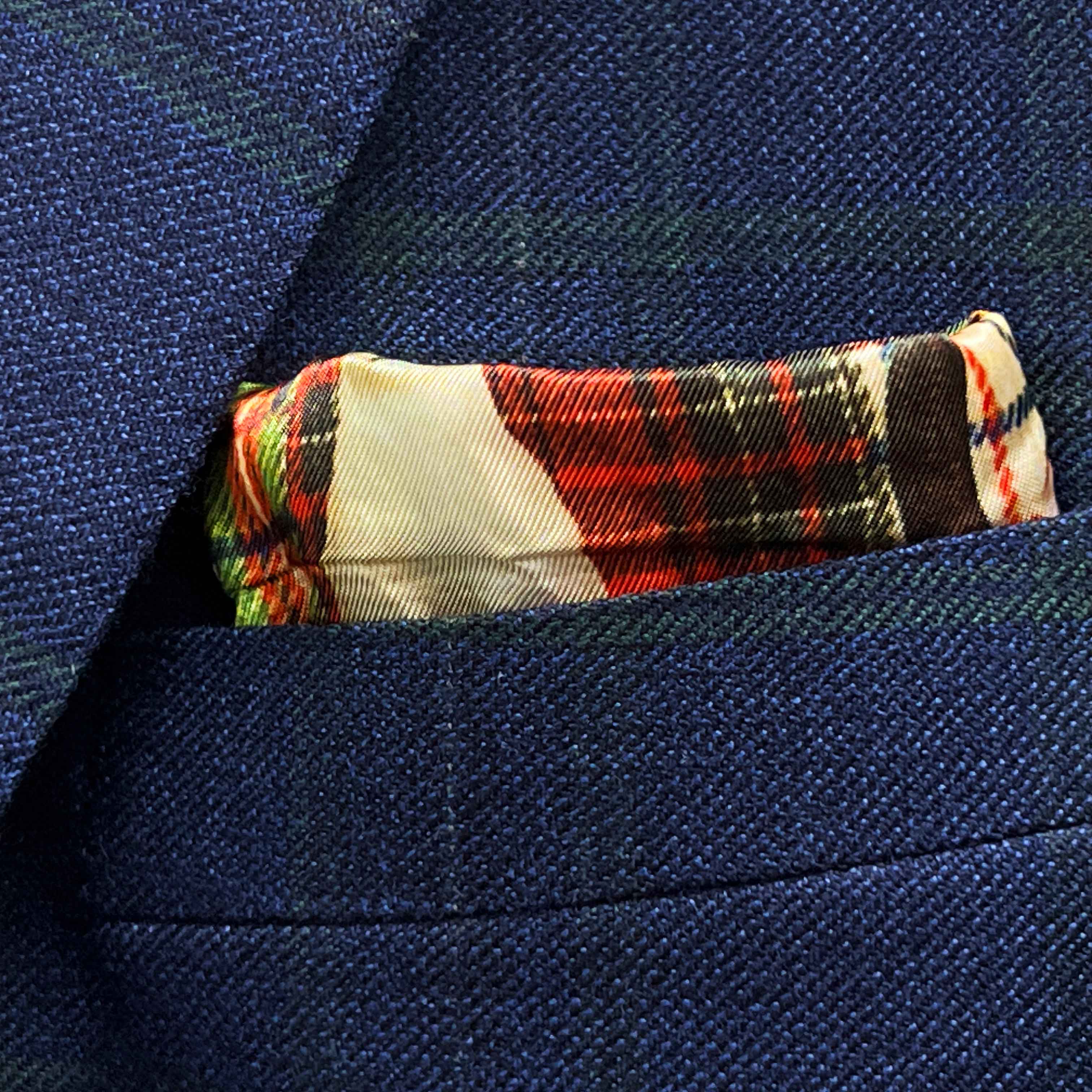 Breast pocket of deep blue navy emerald green overcheck suit jacket with built-in pocket square holder and hand-finished edges
