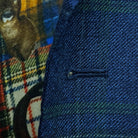 Detailed macro shot of hand-finished buttonhole stitching on deep blue navy emerald green overcheck suit with navy contrast thread