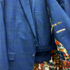 Complete two-piece deep blue navy emerald green overcheck custom suit displayed on hanger showing jacket and trousers with plaid pattern