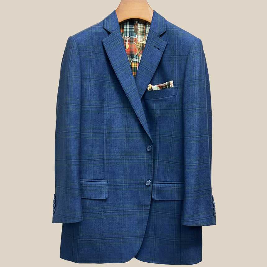 Front button panel of deep blue navy emerald green overcheck suit jacket featuring navy marble horn buttons and hand pick stitching
