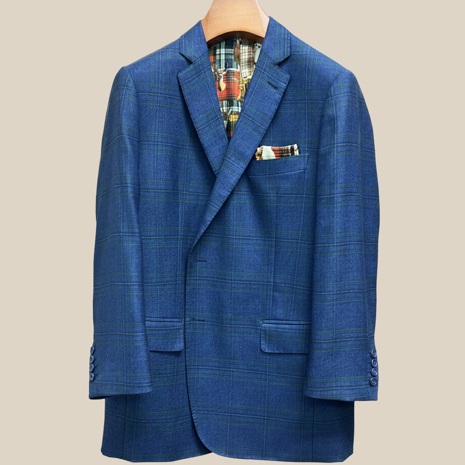 Close-up view of deep blue navy emerald green overcheck suit jacket showing contrast navy accent buttonhole with hand-finished stitching detail