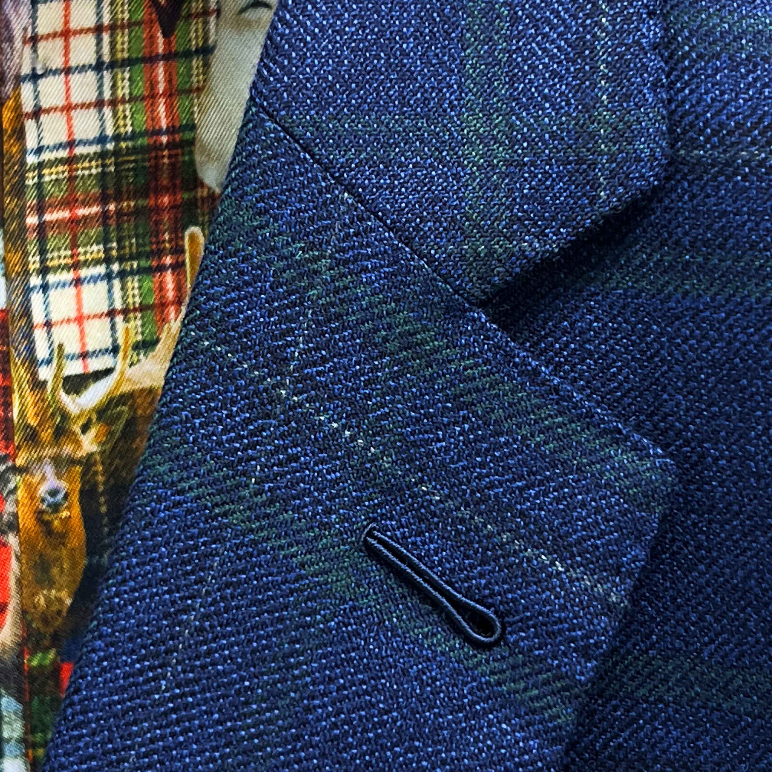 Classic notch lapel detail on deep blue navy emerald green overcheck suit jacket showing hand pick stitching and plaid pattern