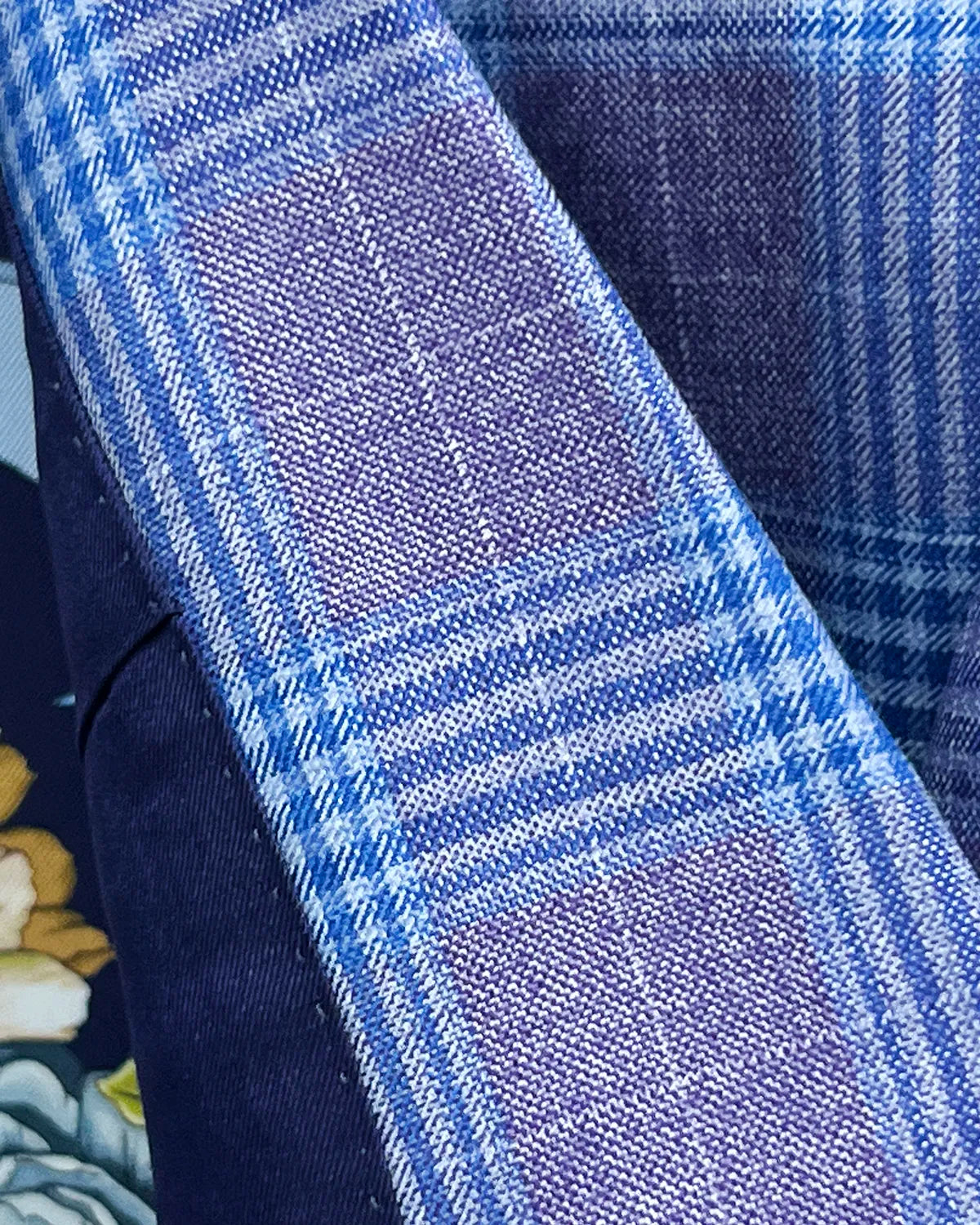 Fabric close up of lilac mauve with cornflower blue Glen plaid men's sport coat showing cloth texture and weave