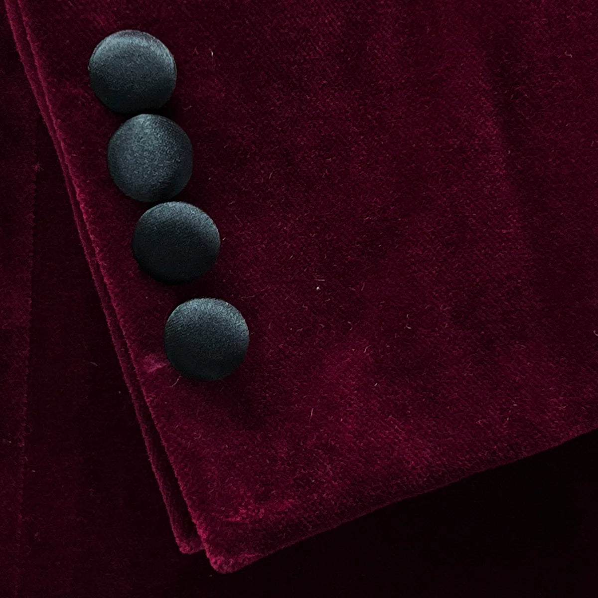 sleeve buttons on a burgundy velvet formal jacket.
