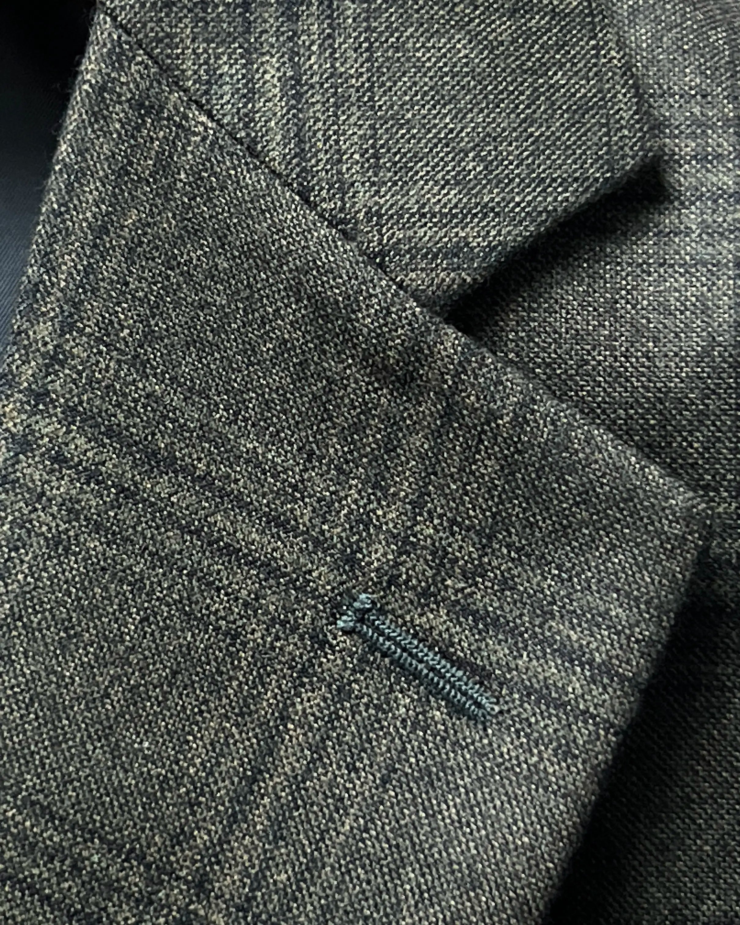 Lapel buttonhole close up of charcoal brown melange tonal Glen Plaid men's sport coat showing matching stitching.