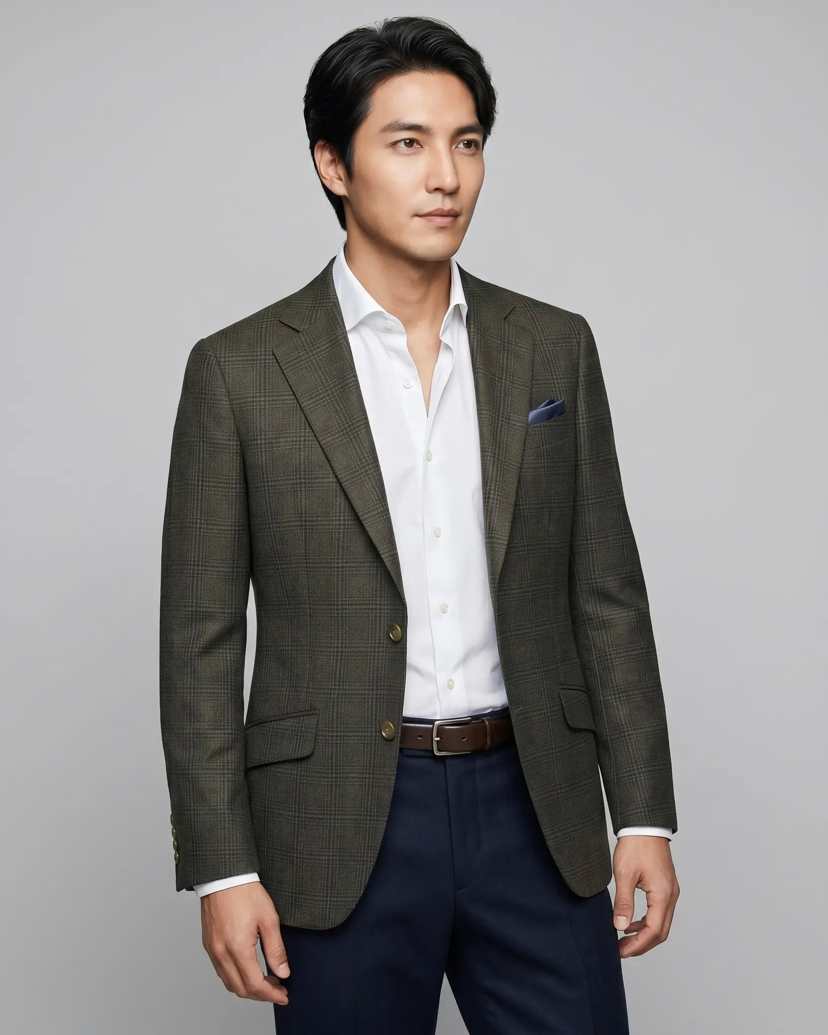 Angled model view of charcoal brown melange tonal Glen Plaid men's sport coat showing the jacket drape, lapel roll, and natural lining glimpse.