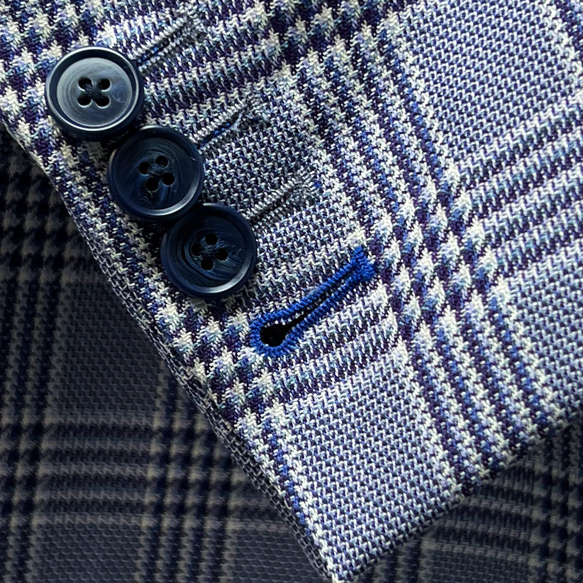 Detail shot of working sleeve buttonholes with royal blue accent stitching