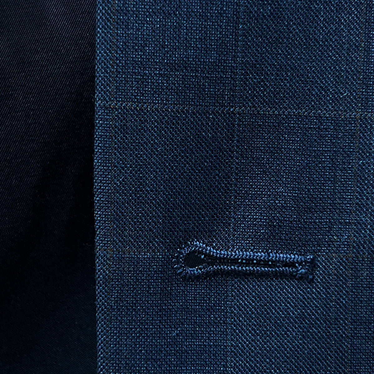 Macro shot of buttonhole detail showing clean stitching