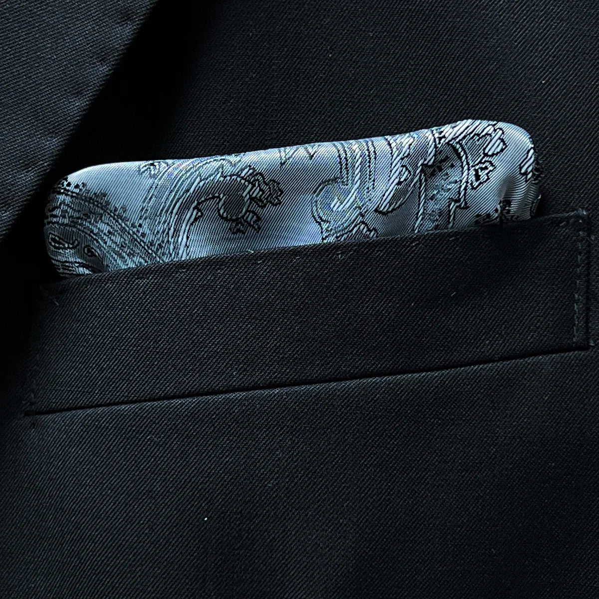 Close-up of a built-in pocket square in the breast pocket of a black Vitale Barberis Canonico suit jacket.