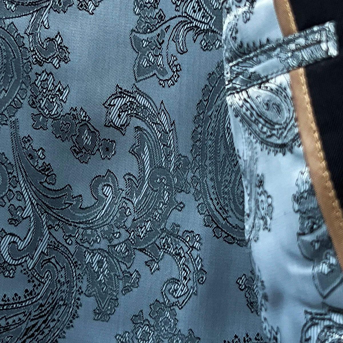 Interior shot of a black Vitale Barberis Canonico suit jacket, focusing on the vibrant silver paisley flash linings.