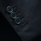 Detailed view of functional buttonholes on the sleeve of a black Vitale Barberis Canonico suit jacket.