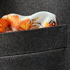 Breast pocket of dark brown plain weave suit jacket with built-in pocket square holder and hand-finished edges