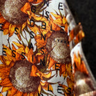 Colorful flash lining detail visible at jacket cuffs and vents in sunflower floral pattern