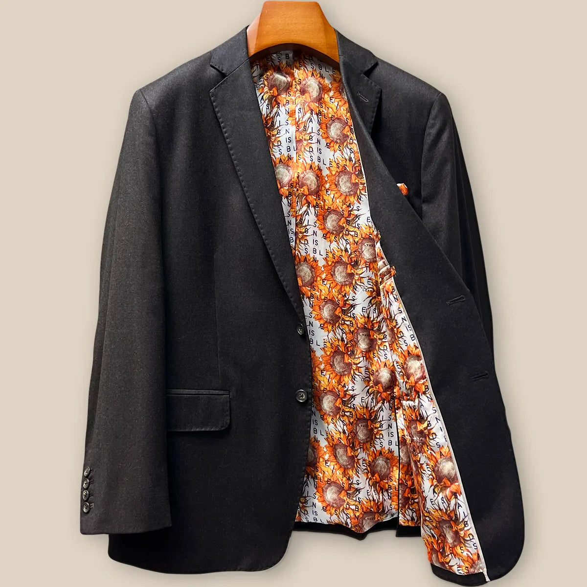Interior left side of dark brown plain weave suit jacket displaying sunflower floral fancy lining with inner pocket