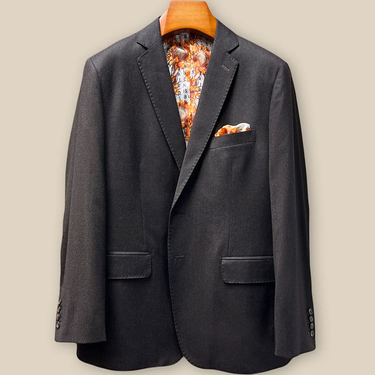 Close-up view of dark brown plain weave suit jacket showing contrast medium brown accent buttonhole with hand-finished stitching detail