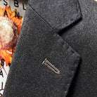 Classic notch lapel detail on dark brown plain weave suit jacket showing hand pick stitching