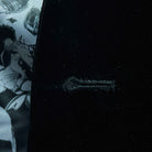 Detailed macro shot of hand-finished buttonhole stitching on black silk velvet formalwear tuxedo with contrast thread