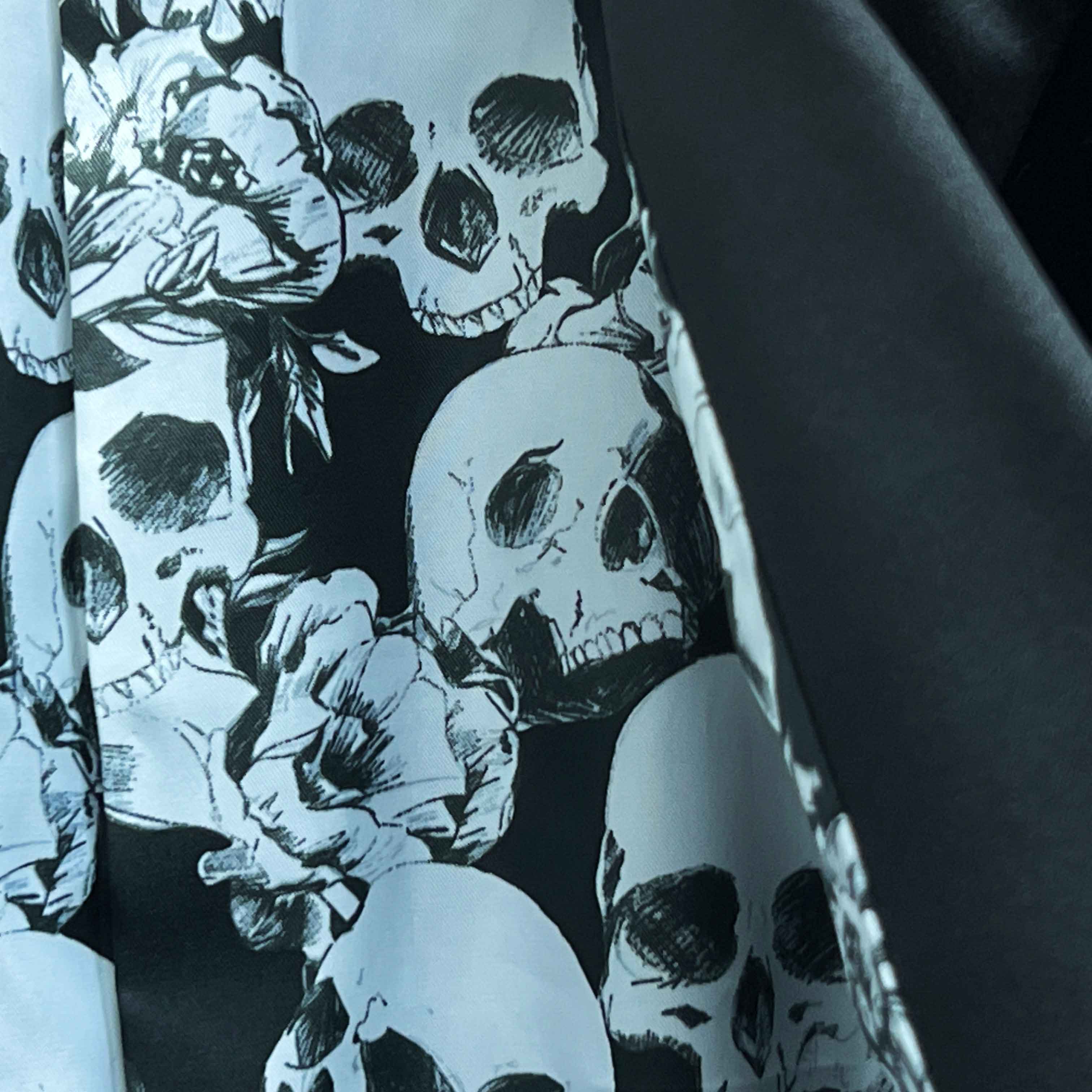 Colorful flash lining detail visible at jacket cuffs and vents in black and white skull pattern