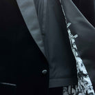 Complete two-piece black silk velvet formalwear tuxedo displayed on hanger showing jacket and trousers with satin trimming