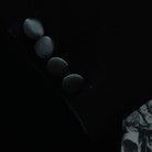 Formalwear tuxedo jacket sleeve cuff showing functional buttonholes with satin trimming on black silk velvet fabric