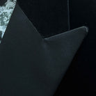 Satin peak lapel detail on black silk velvet formalwear tuxedo jacket showing hand pick stitching and silk satin trimming