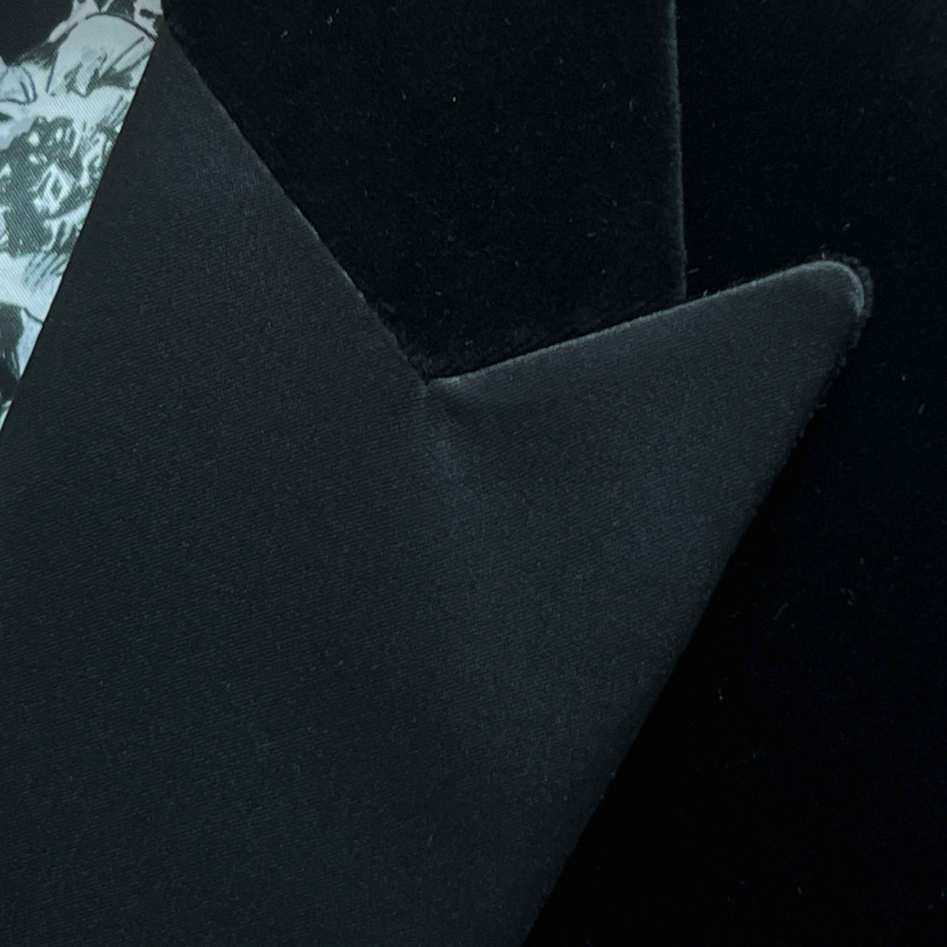 Satin peak lapel detail on black silk velvet formalwear tuxedo jacket showing hand pick stitching and silk satin trimming