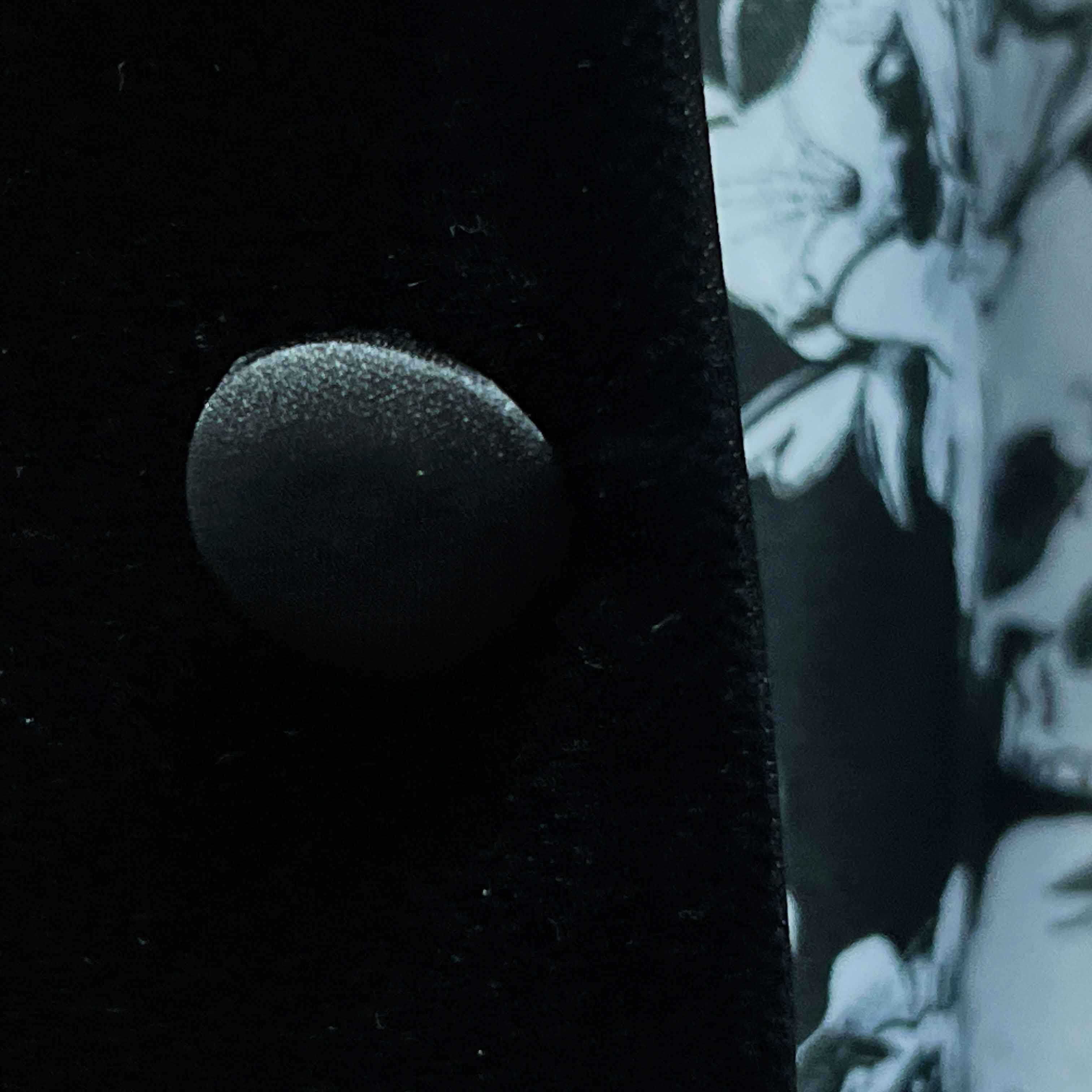 Close-up of black silk satin covered buttons on black silk velvet formalwear tuxedo jacket showing lustrous finish
