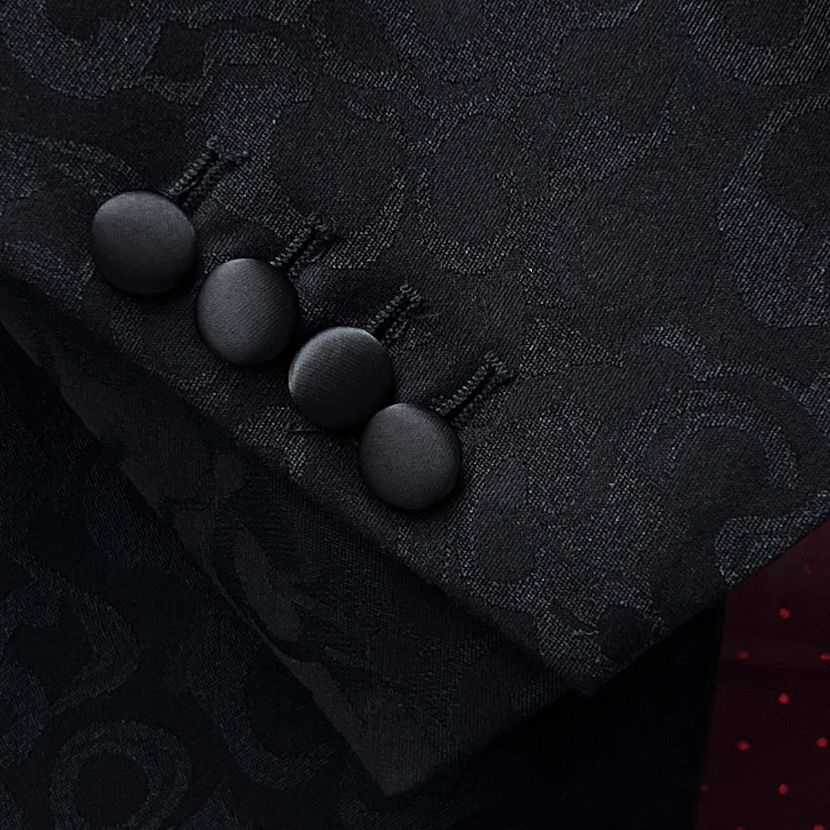 Tuxedo jacket sleeve cuff showing functional buttonholes with contrast black satin accent stitching on self floral fabric