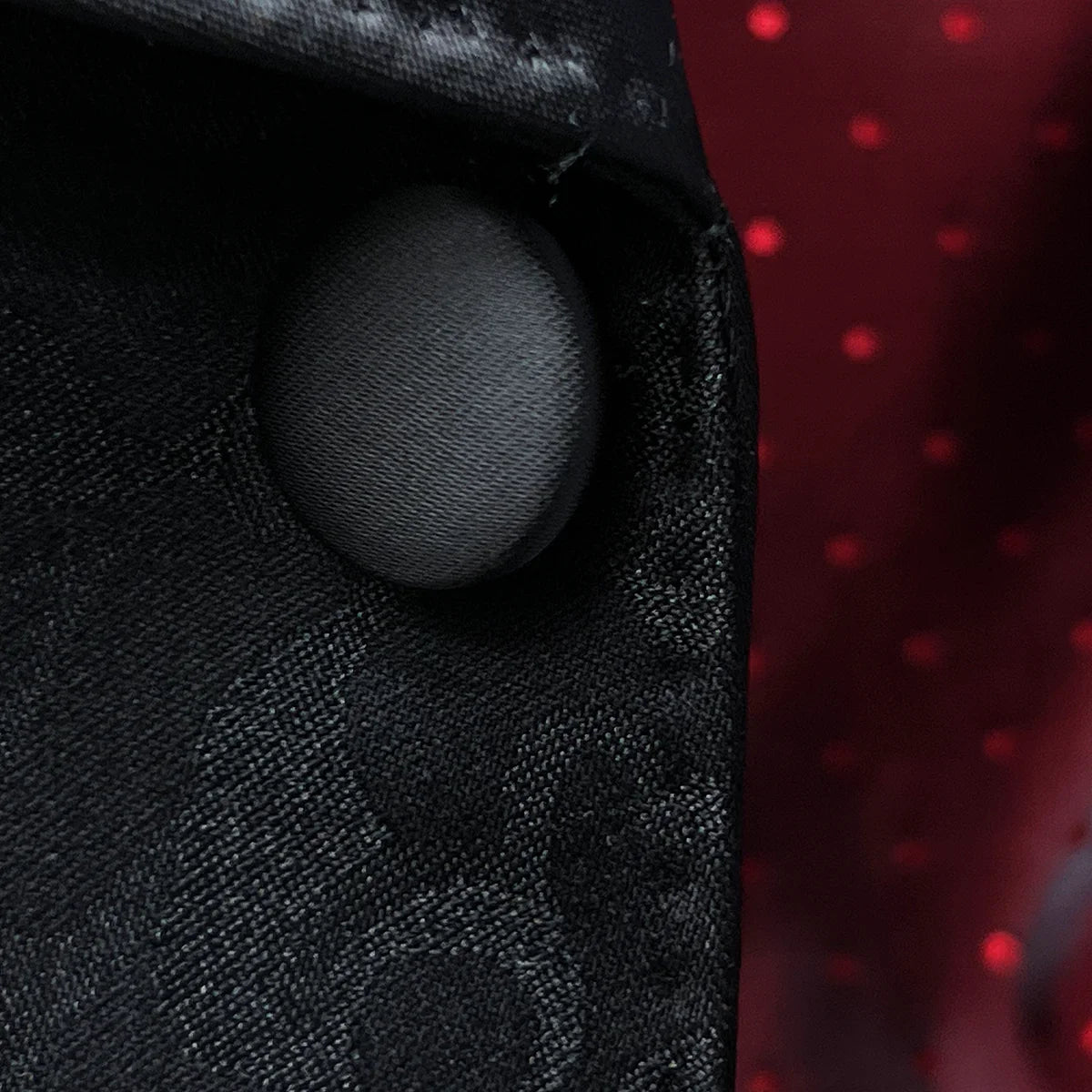 Close-up of black silk satin covered buttons on self floral tuxedo jacket showing lustrous finish