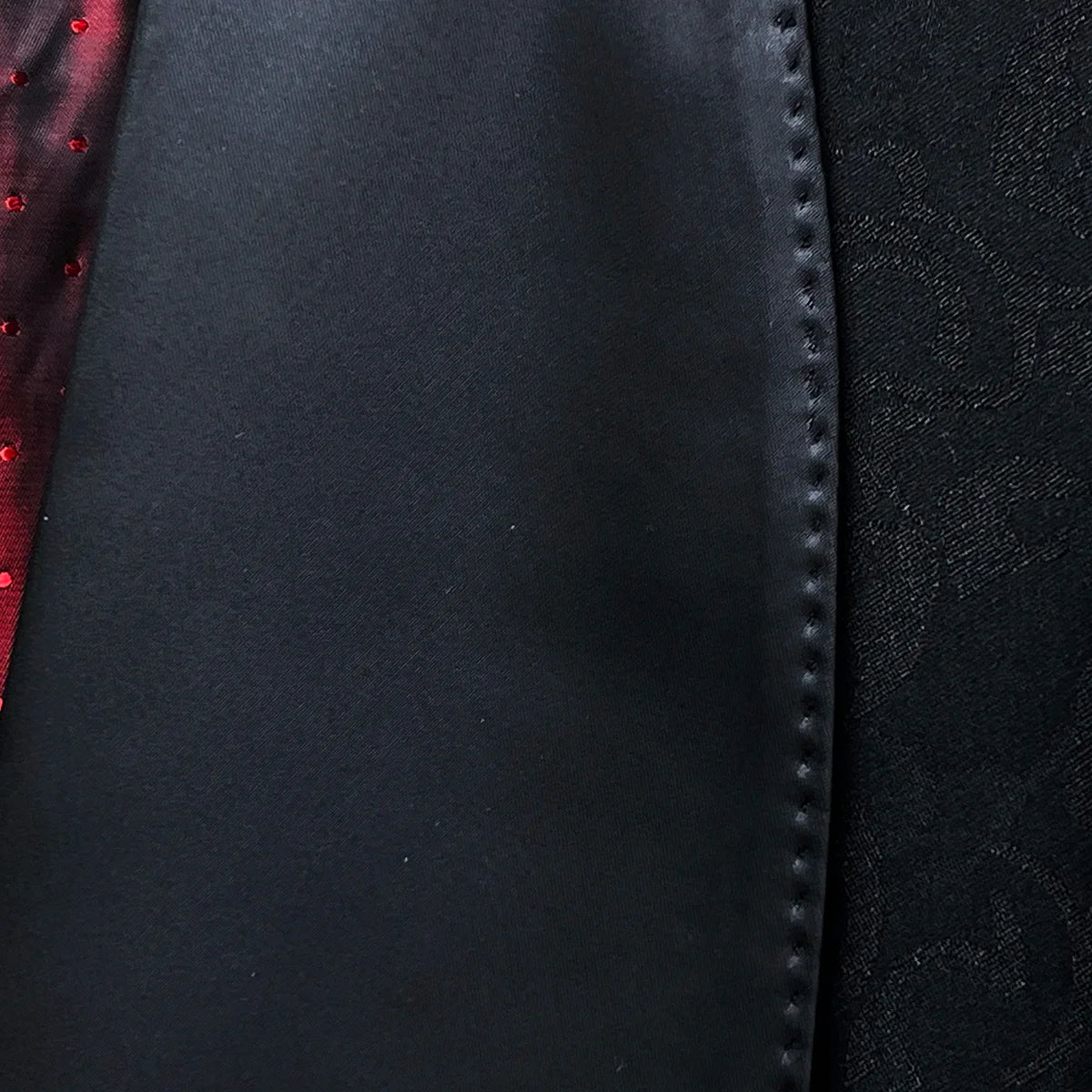 Classic shawl lapel detail on black self floral tuxedo jacket showing hand pick stitching and satin trim