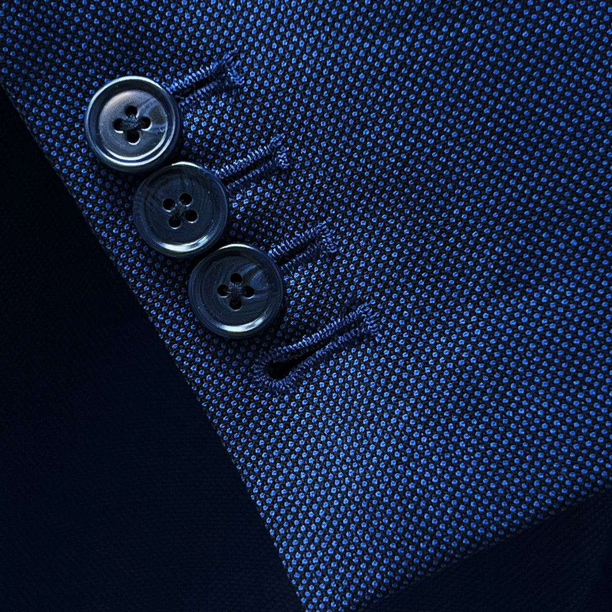 Close-up of working sleeve buttonholes with navy horn buttons