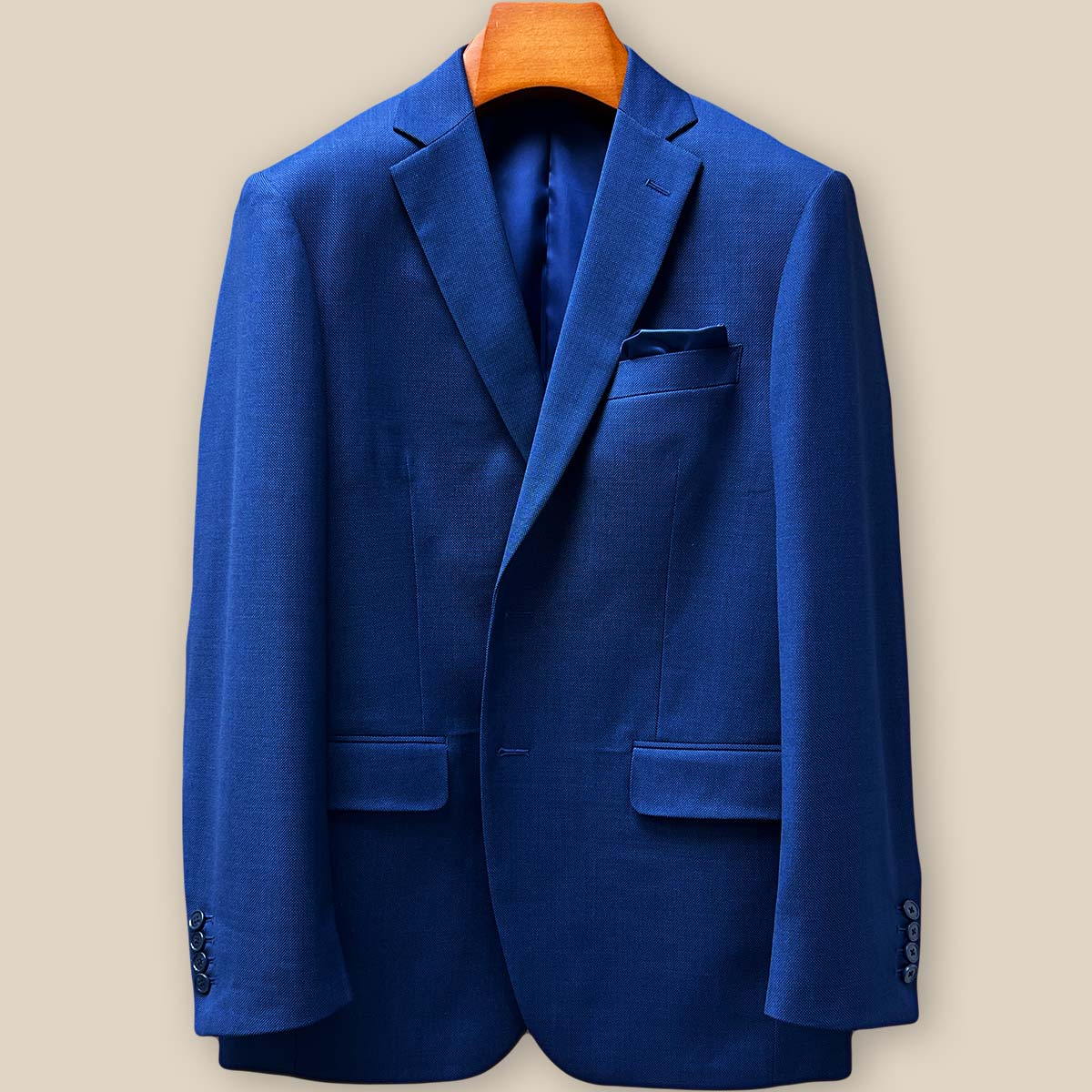 Close-up of the blue birdseye suit jacket's front panel, showcasing precision stitching and premium horn button placement