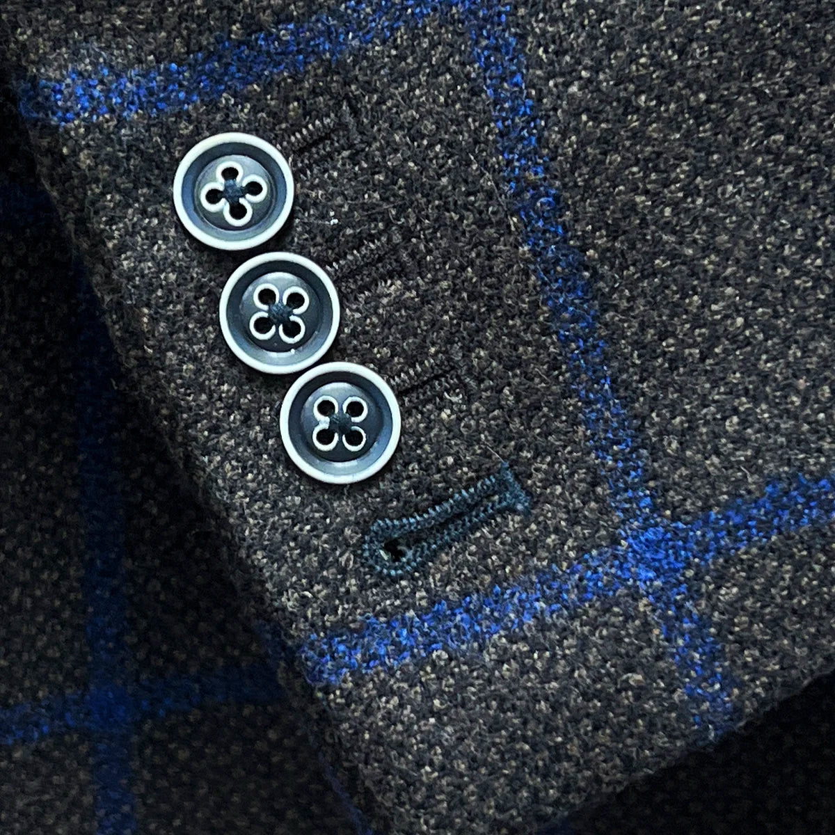 Functional sleeve buttonholes with navy accent buttonhole on the Westwood Hart brown with royal blue windowpane sportcoat.
