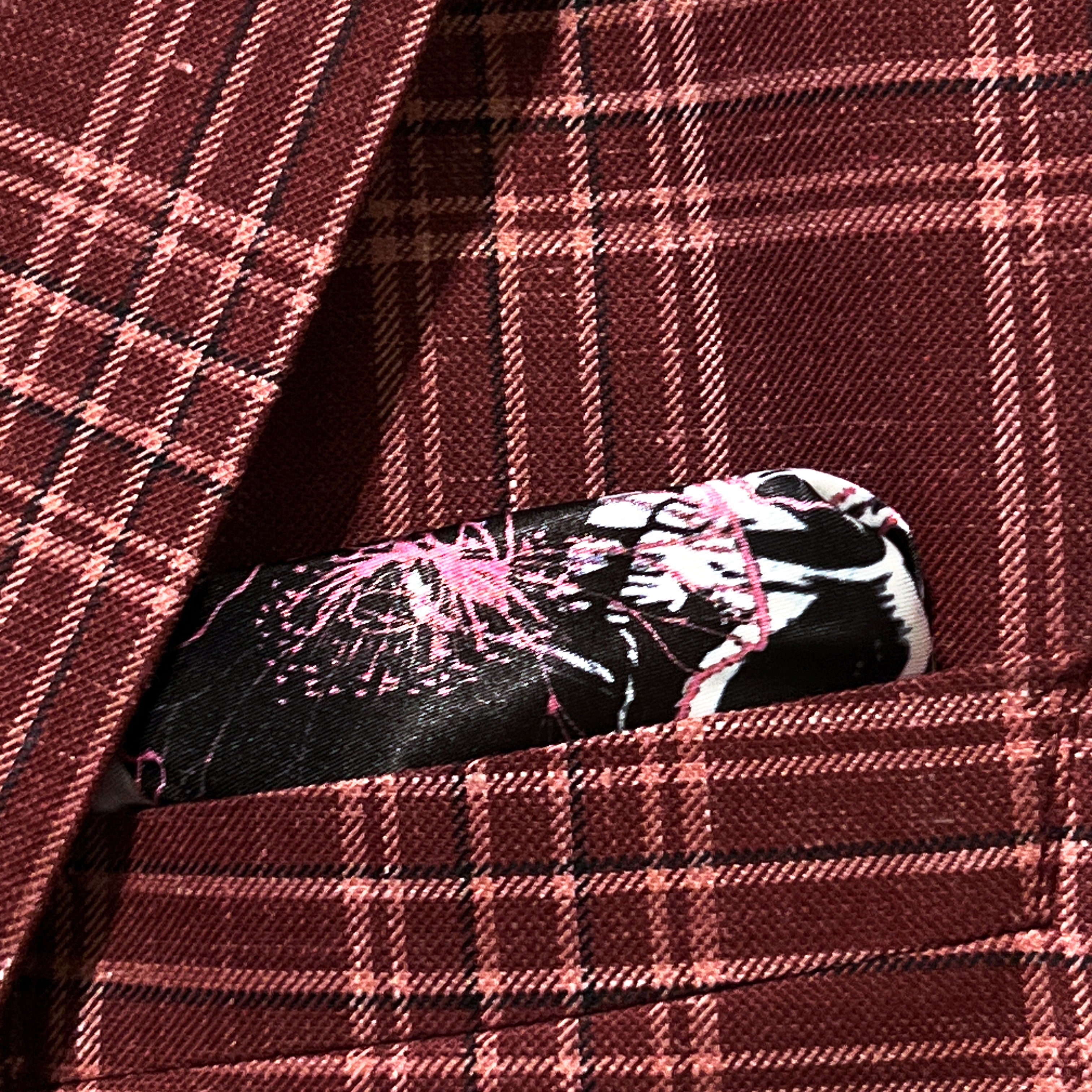 Breast pocket of burgundy plaid sport coat with built-in pocket square holder and hand-finished edges
