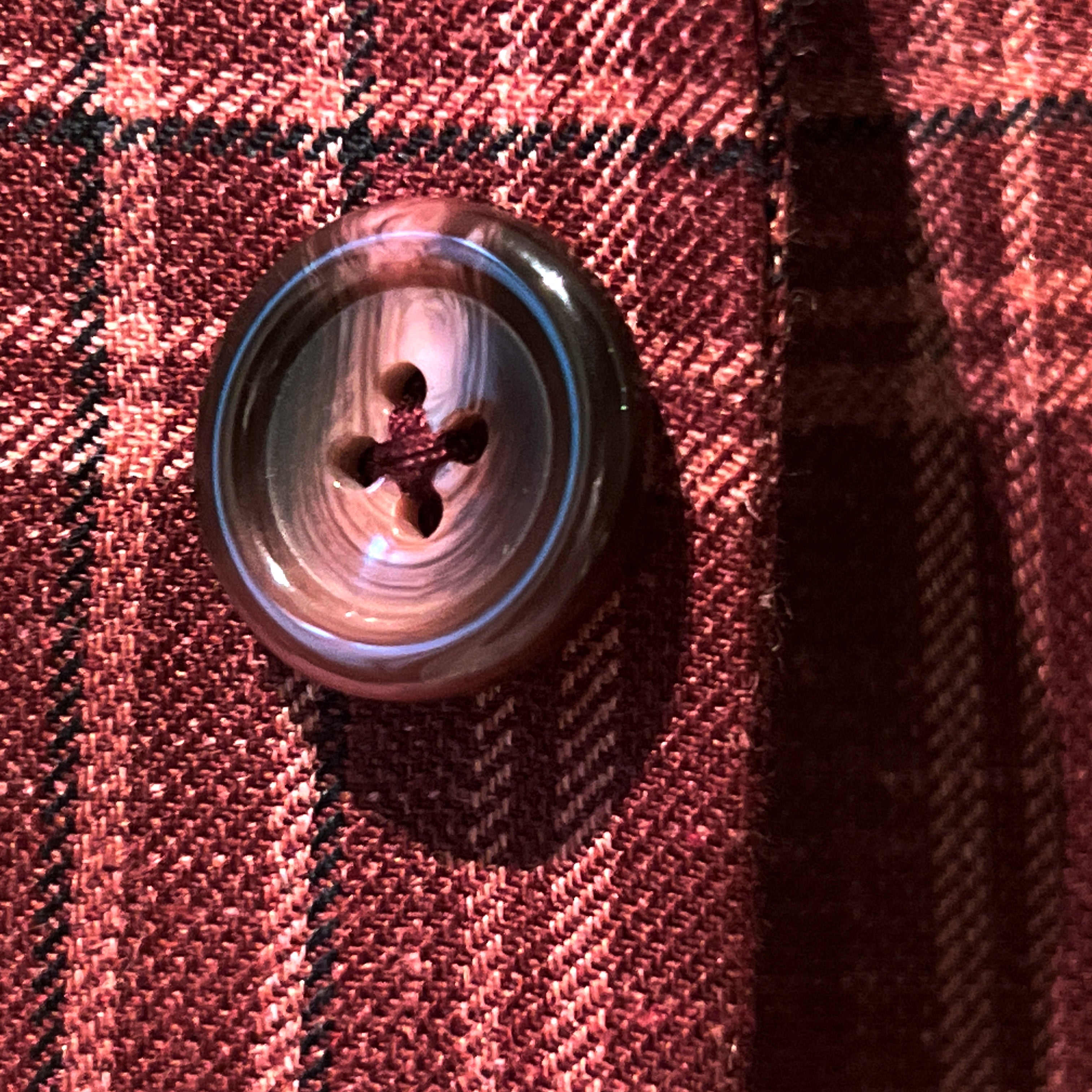 Close-up of burgundy marble buttons on burgundy plaid sport coat showing natural marble-like patterns