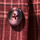 Close-up of burgundy marble buttons on burgundy plaid sport coat showing natural marble-like patterns