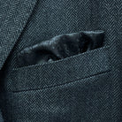 Breast pocket of charcoal grey herringbone sport coat with built-in pocket square holder and hand-finished edges