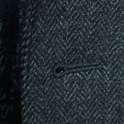 Detailed macro shot of hand-finished buttonhole stitching on charcoal grey herringbone sport coat with edge pick stitching
