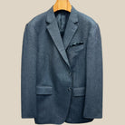 Front button panel of charcoal grey herringbone sport coat featuring charcoal horn buttons with light grey marbling and hand pick stitching