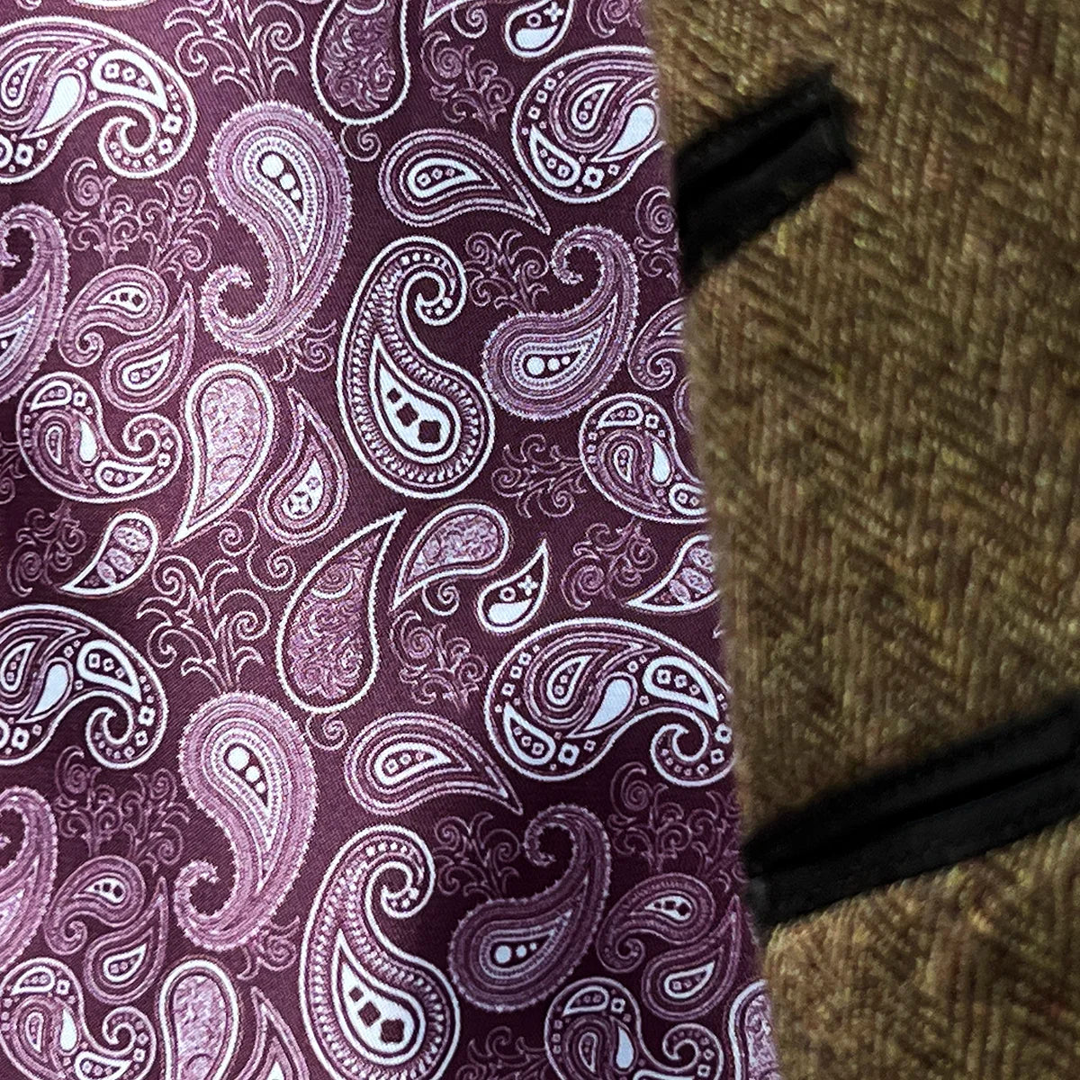 Detail shot of burgundy paisley lining flash beneath sleeve