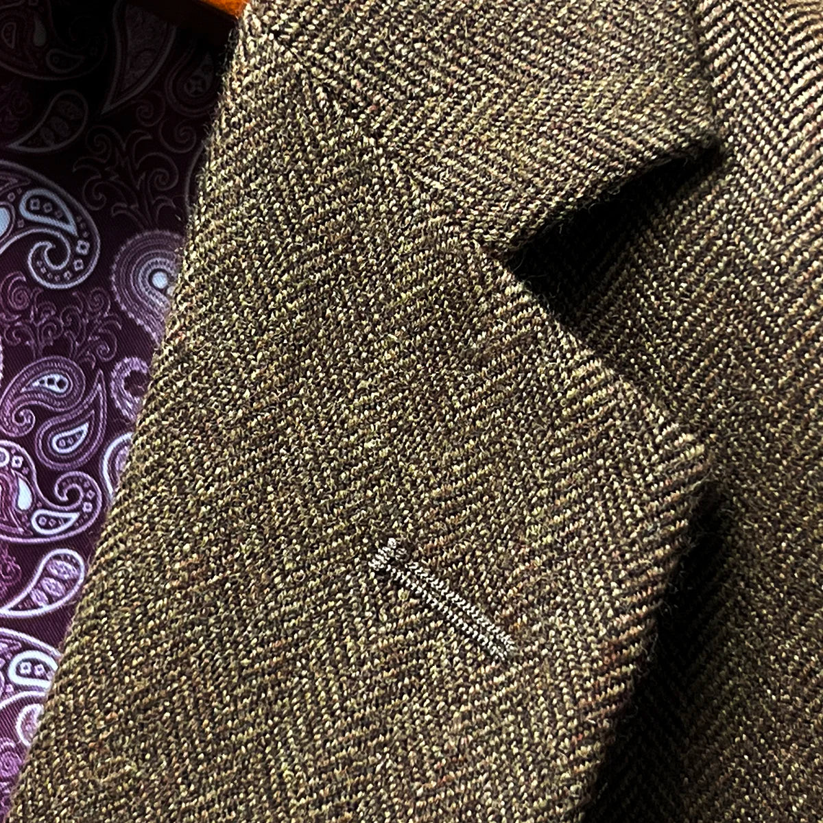 Close-up of classic notch lapel showing herringbone pattern and construction